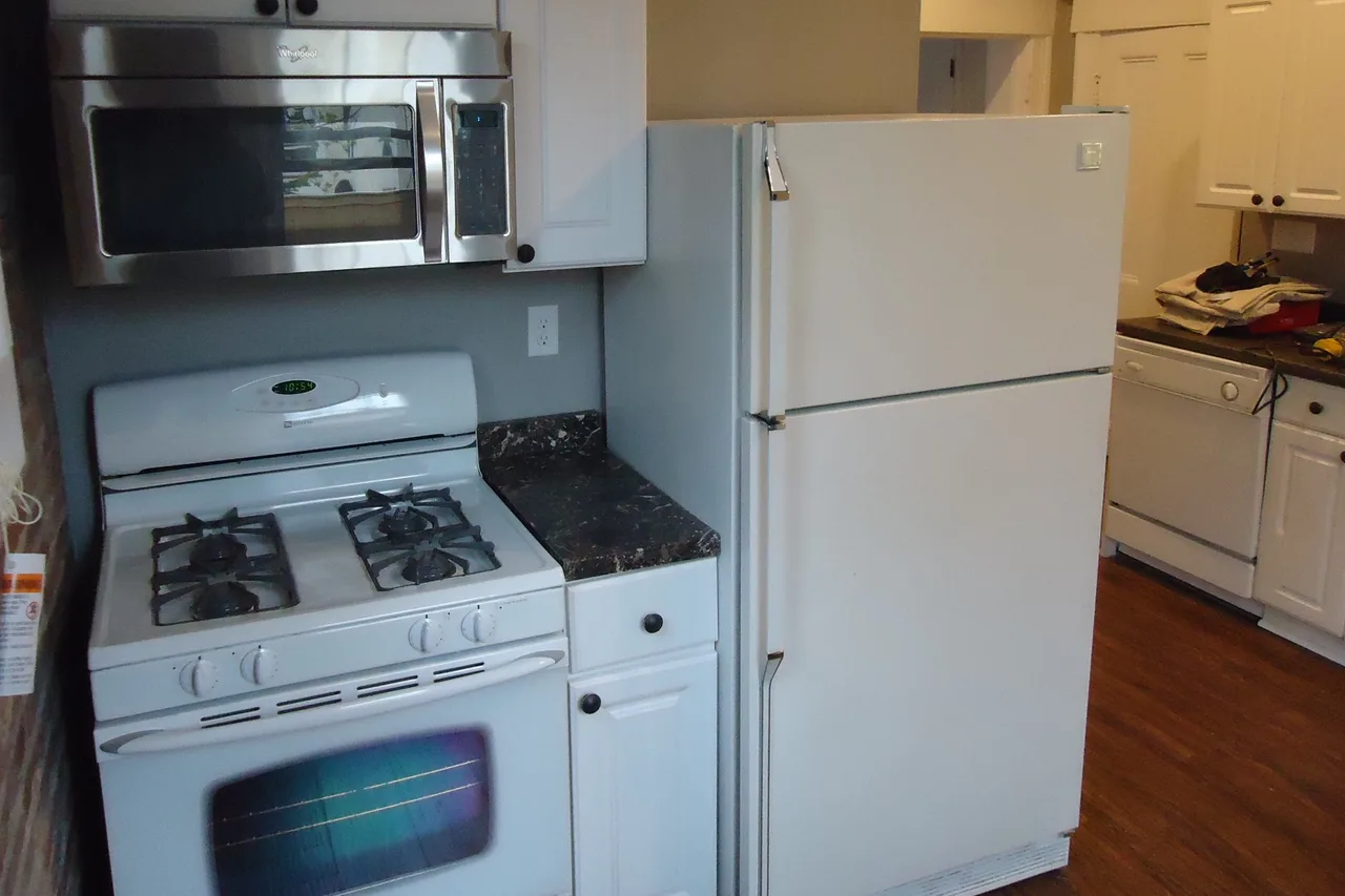 A kitchen with newly installed cabinets, appliances and flooring