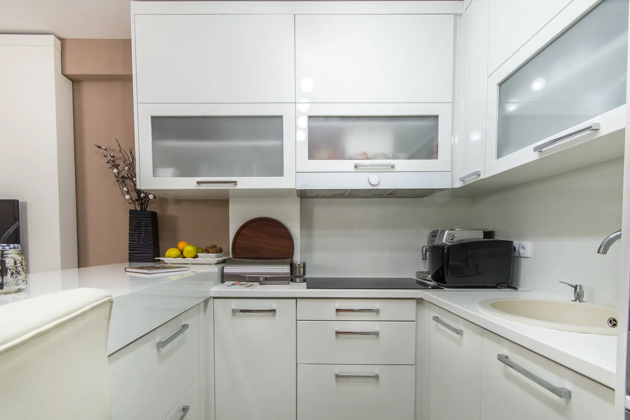 A bright, tidy white kitchen with clear countertops